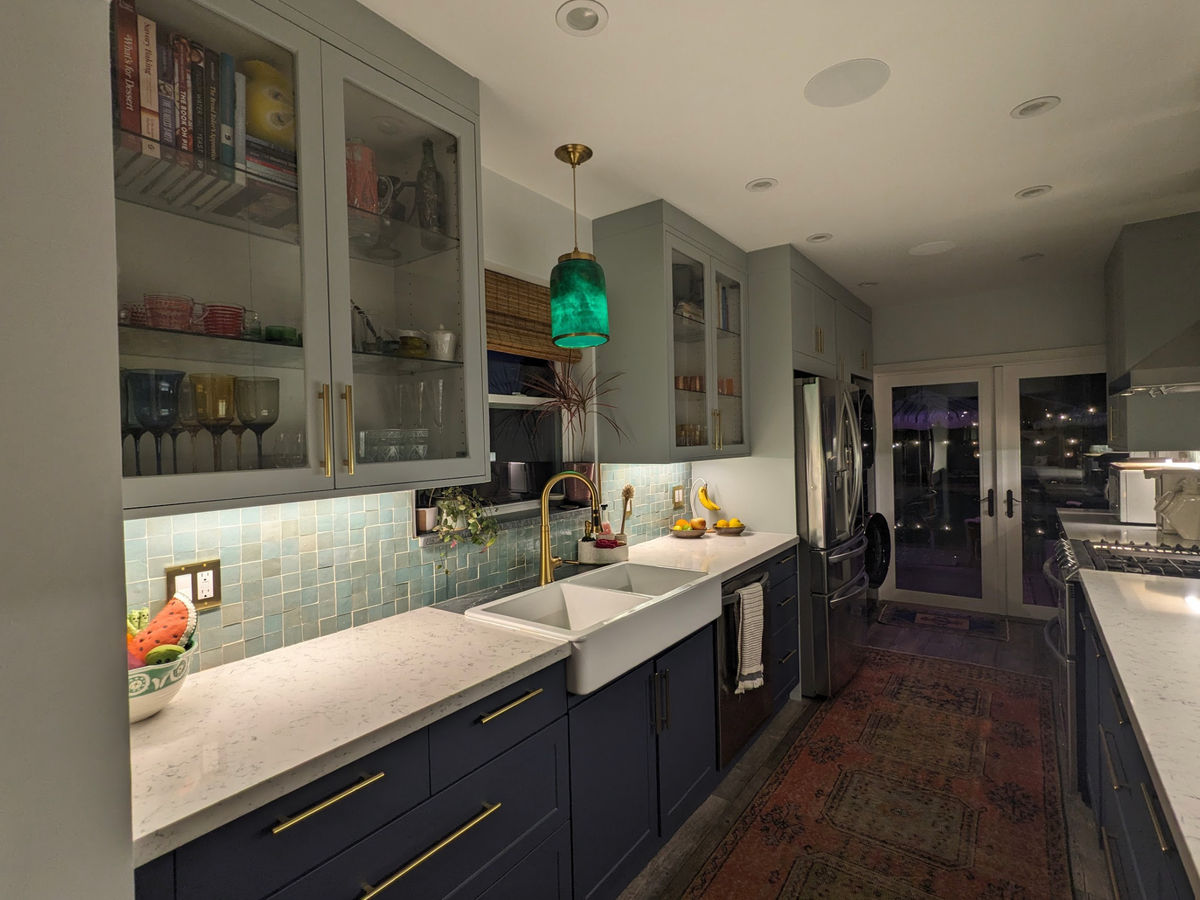 Custom galley kitchen remodel with navy blue shaker cabinets and green zellige tile backsplash by JSP Construction in Los Angeles