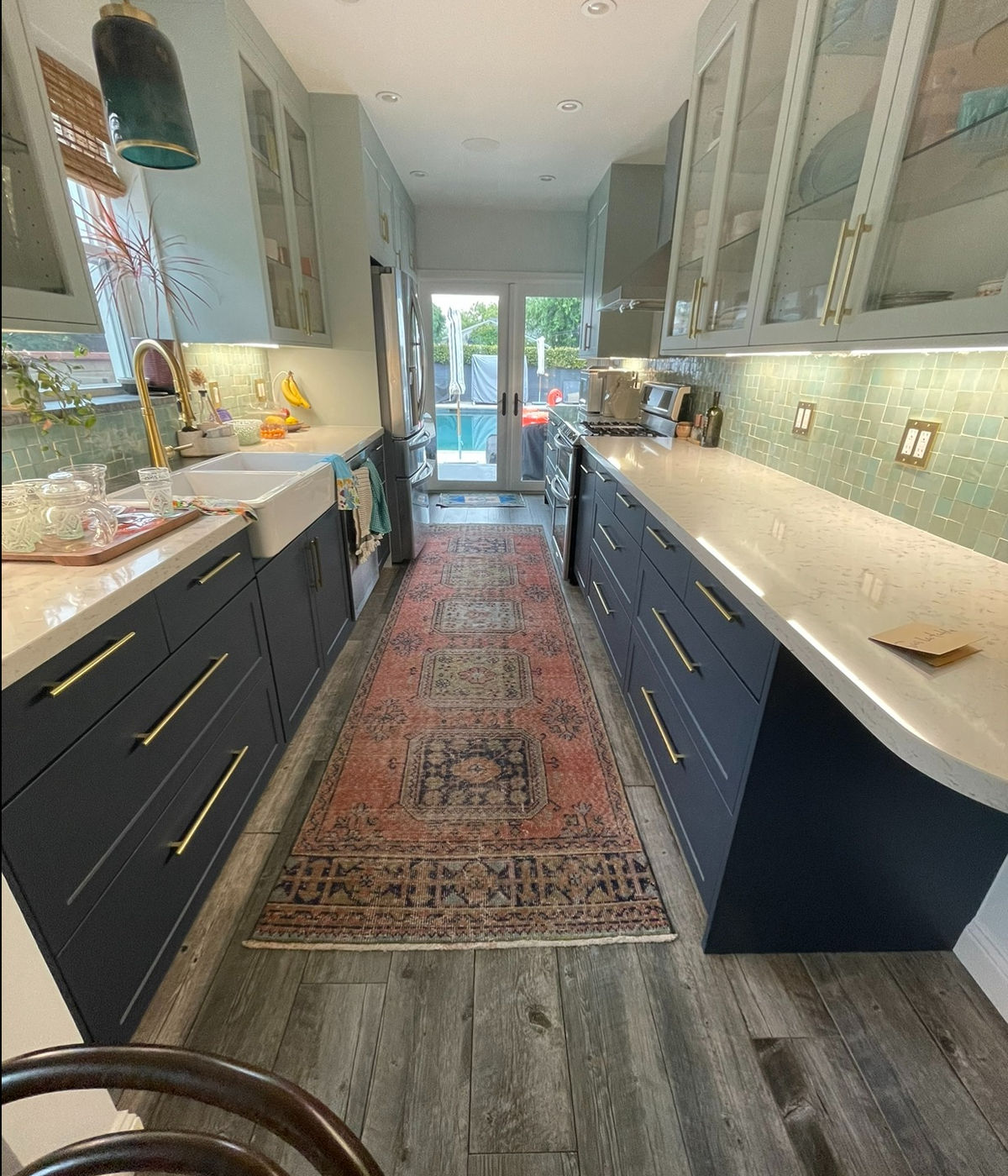 Kitchen remodel with navy blue cabinets, quartz countertops, and gold hardware by JSP Construction in Northridge CA